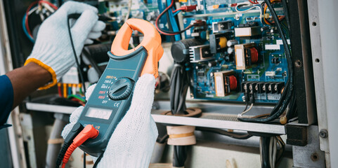 Technician is checking air conditioner refrigerant system maintenance and check switch board control