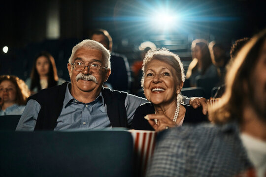 Senior couple watching a movie in the theater with popcorn