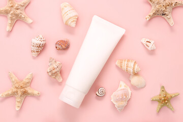 cosmetic moisturizer tube bottle, seashells and sea ​​stars on pink background. Body cream,...