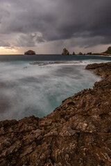 Stony coast with sharp rock formations on a bay in the sea. rainy sunrise, dramatic mood. Pointe des Chateau overlooking Pointes des colibris on Grande Terre, Guadeloupe, French Antilles, Caribbean