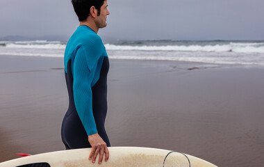 Surfer observing the sea before going surfing, copy space.