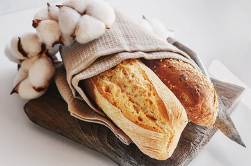 Assortment of various delicious freshly baked breads on a white wooden background. Ciabatta, grissini, pastries, baguette of various varieties. Homemade healthy bread, close-up