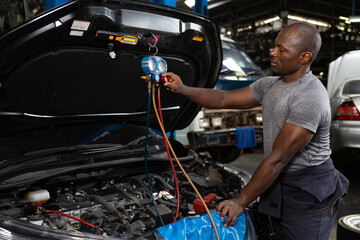 mechanic worker fixing and checking a car air conditioning system in automobile repair shop