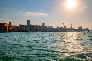 Sunlit Waters of Dubai Creek with Historic Architecture