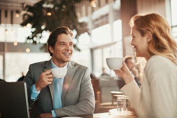 Businessman and businesswoman having a meeting at an indoor cafe