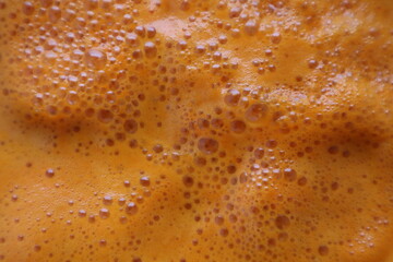 close-up of fresh orange foam with bubbles