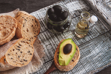 homemade rye sourdough bread with black olives. Breakfast sandwich made from homemade bread with olives, avocado and sun-dried tomatoes. Homemade sourdough bread recipe idea