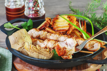 chicken kebab with artichoke, potatoes with herbs and spices. Close-up of a white meat chicken and turkey meat dish
