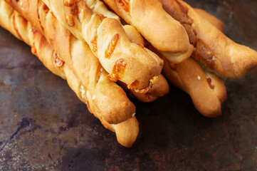 handmade grissini. Italian grissini or salted breadsticks with parmesan and onions on a light stone background. Fresh Italian appetizer. Copy space.