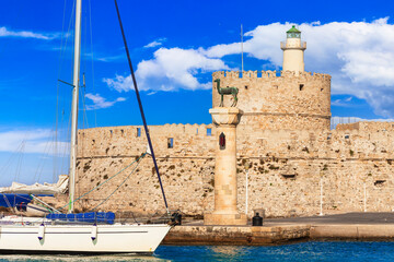 Greece travel, Dodecanese. Rhodes island.  Mandraki Harbor with symbol statue of deer and saillboats - 746725787