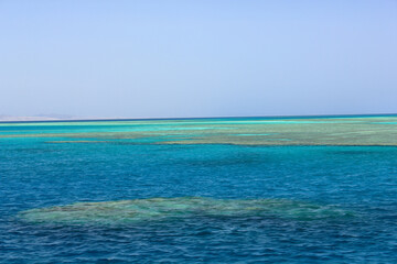 Captivating view of Egypt's Red Sea coral reef near Marsa Alam, Hamata Islands. Crystal-clear turquoise waters under a warm, sunny sky.