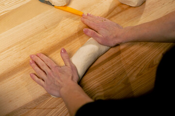 close up layout in a professional kitchen of bakers at the table process the dough and form it into mold
