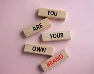 You are your own brand symbol. Wooden blocks with words You are your own brand. Beautiful pink...