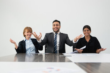 Three joyful business professionals tossing papers in the air in a bright office setting, celebrating success.