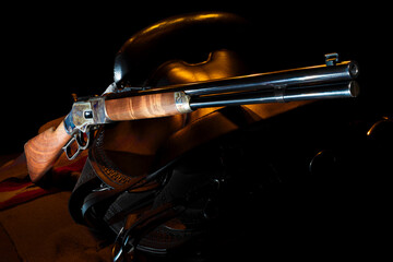 Orange rim light on the lever action carbine and saddle - obrazy, fototapety, plakaty