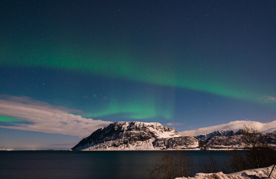 Beautiful green-colored northern lights over a fjord on the Lofoten Islands in Norway