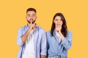 Quiet gesture, couple with fingers on lips