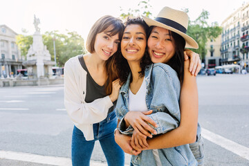 Portrait of three group of diverse young girls standing at city street. Female friendship and...