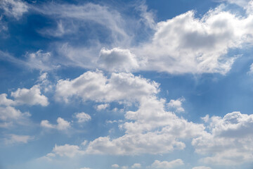 Blue sky with puffy cloud formations, natural background