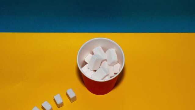 Sugar cubes going into coffee cup. Stop motion creative concept.