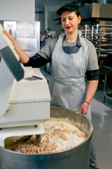 of a dough kneading machine in a professional kitchen a girl closes the lid