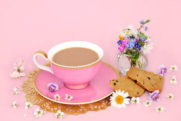 Cup of tea with homemade chocolate chip cookies, Spring flowers and wildflowers in a vase and scattered. Luxury teacup on gold doily on pink background. - 746764500