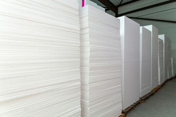 A large blocks of Styrofoam are stacked in a warehouse.