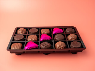 Box of chocolates on a pink background. Chocolate candies close-up.