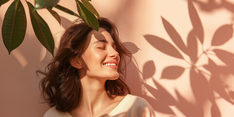 Close up portrait of happy brunette woman standing in dappled sunlight and smiling with gratitude, pink background
