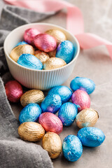 Easter chocolate eggs wrapped in aluminium foil on kitchen table.