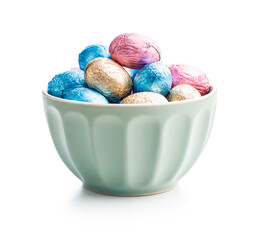 Easter chocolate eggs wrapped in aluminium foil in bowl isolated on white background.