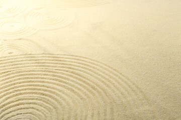 Fototapeta na wymiar Zen rock garden. Circle pattern on beige sand, closeup
