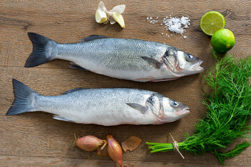 Freshly caught sea bass, loup de mere, natural fish ready to prepare on wooden background for fish cuisine, prepared baked, fried or boiled