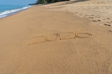 Fototapeta na wymiar 2026 written in the sand on the beach - Happy New Year