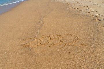 2032 written in the sand on the beach - Happy New Year