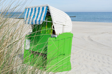 beautiful traditional green beach chair in the sand on a sunny, relaxed day on the coast of...