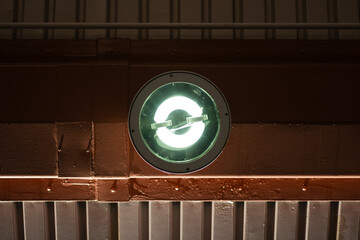 Looking up at a halogen lamp at the platform of a train station. The linear designs of the...