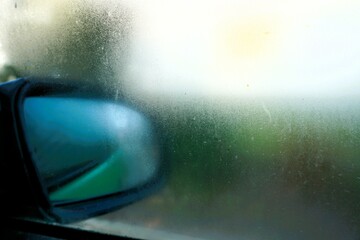 Beschlagene Autoscheibe vor Außenspiegel bei Frost, Kälte und Eis am Morgen im Winter