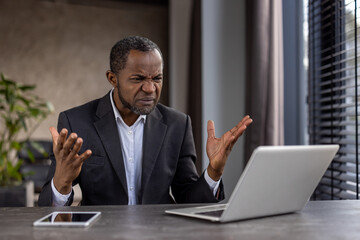 Perplexed african american businessman experiencing problems at work in office