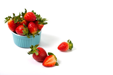Red strawberries in a blue pial on a white background. Strawberries on a white background