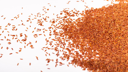 Long brown rice scattered on a white background. Photo of rice on a white background.