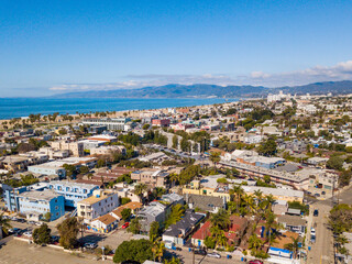 Naklejka na ściany i meble Aerial drone view over Venice looking towards the beach and the Santa Monica Mountains on a clear blue sky day.