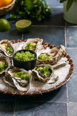 Oysters With Spicy Cucumber & Lime Granita, gteen fresh basil, blue background