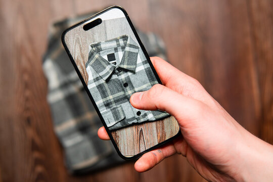 Selling second-hand clothes online. Taking photos of a plaid shirt with your phone