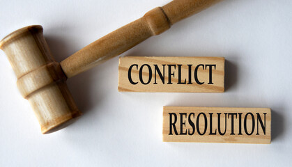 CONFLICT RESOLUTION - words on wooden blocks on a white background with a judge's gavel.