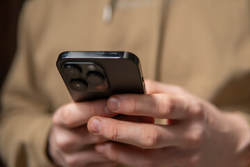 close-up of a man typing on a smartphone