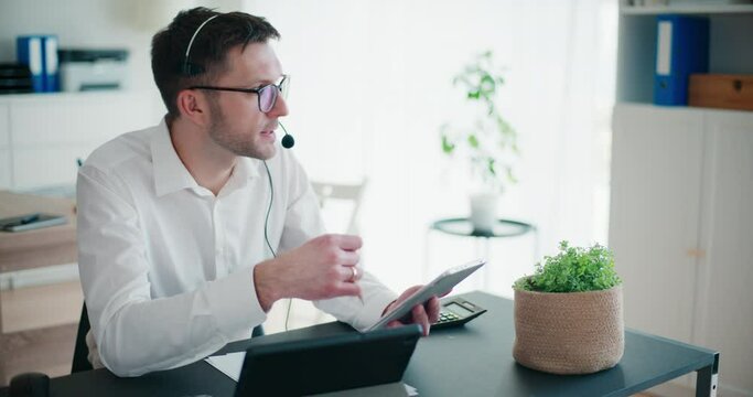 Businessman talking through headphones using digital tablet