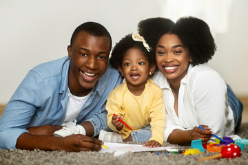 Cute african american baby girl enjoying development activities with parents