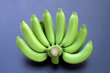 Green banana on dark background.