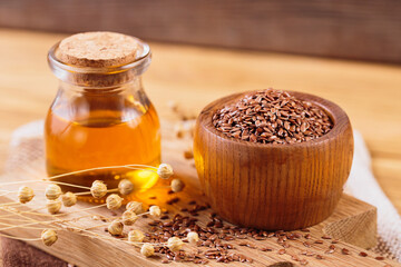 Brown linen seeds, flaxseed vegetable oil on rustic wooden background. Healthy super food